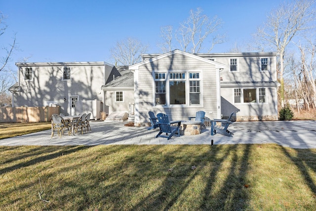 back of house featuring an outdoor fire pit, a patio, and a lawn