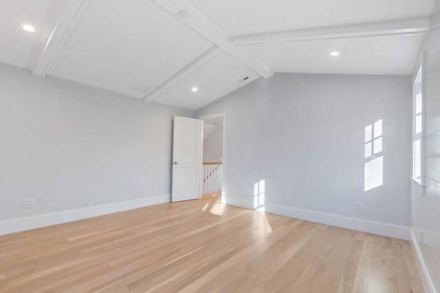 spare room with light hardwood / wood-style flooring and vaulted ceiling with beams