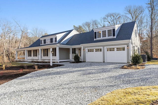 view of front of house featuring a porch, a garage, and central AC