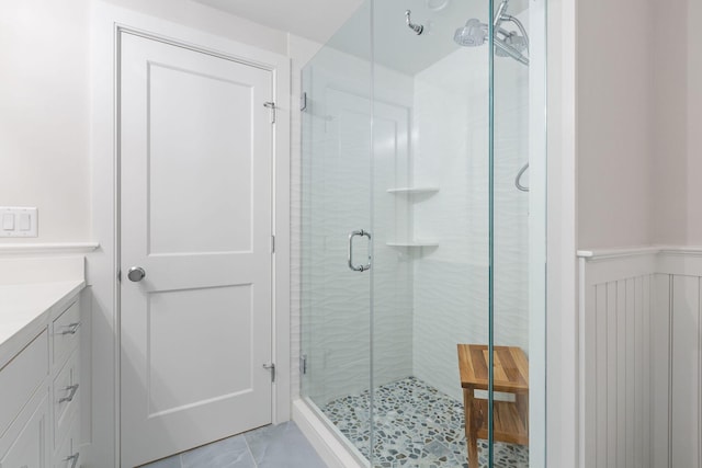 bathroom with tile patterned floors, a shower with door, and vanity