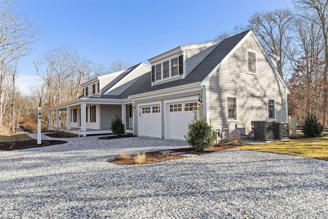 view of side of home with central AC unit, a porch, and a garage