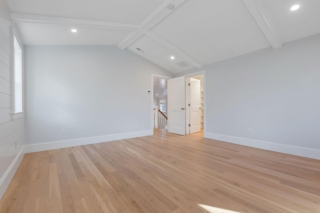 spare room with light hardwood / wood-style floors and vaulted ceiling with beams