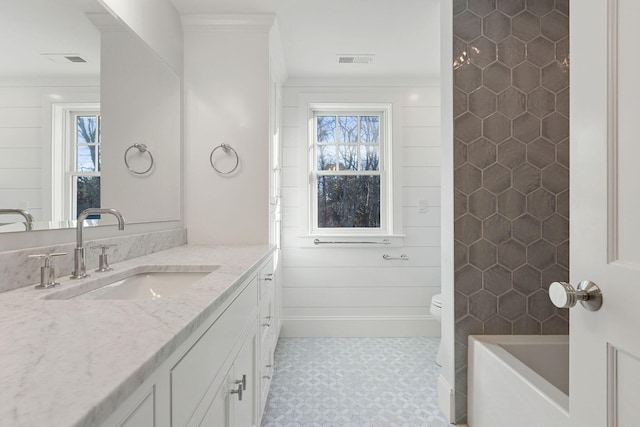 bathroom featuring plenty of natural light, toilet, vanity, and crown molding