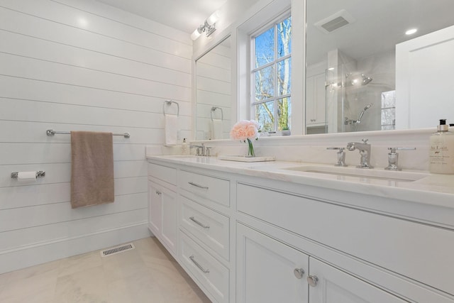 bathroom featuring a shower, vanity, wood walls, and tile patterned flooring