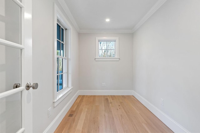 spare room with light hardwood / wood-style floors and crown molding