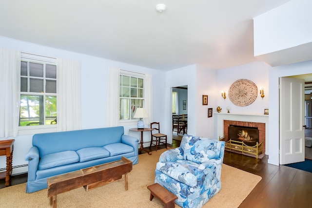 250 Scraggy Neck Rd, Cataumet, MA 02534 - living room with wood finished floors, a fireplace, and a baseboard heating unit