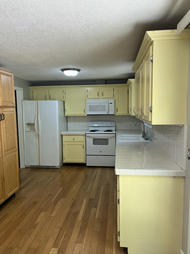 12 Pine Ter, East Sandwich, MA 02537 - kitchen with white appliances, tile countertops, dark wood-style floors, a textured ceiling, and backsplash