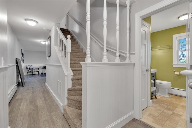 194 John Joseph Rd, Harwich, MA 02645 - staircase with baseboard heating, a wainscoted wall, and a decorative wall