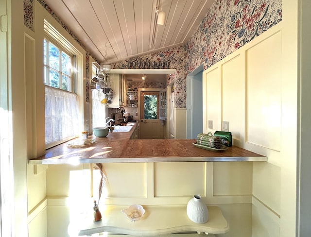 3 Fishburn Ct Unit U2, Provincetown, MA 02657 - kitchen with wallpapered walls, plenty of natural light, vaulted ceiling, a wainscoted wall, and a decorative wall