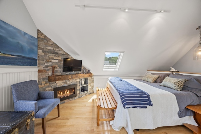 10 Seashore Park Dr Unit Ugg, Provincetown, MA 02657 - bedroom with vaulted ceiling, a stone fireplace, wood finished floors, wainscoting, and a skylight