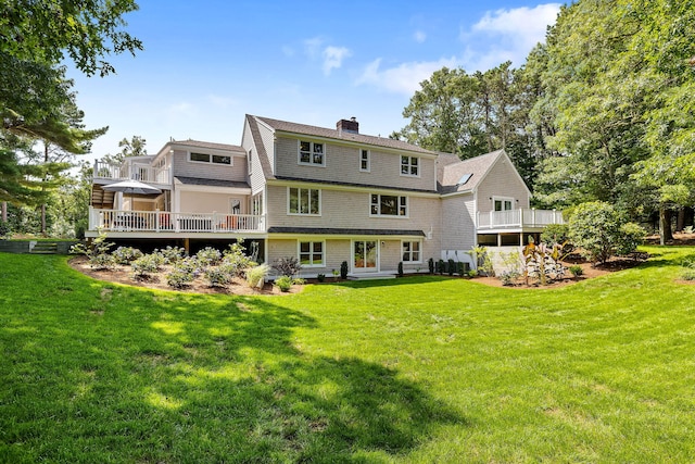 back of property with a deck and a yard