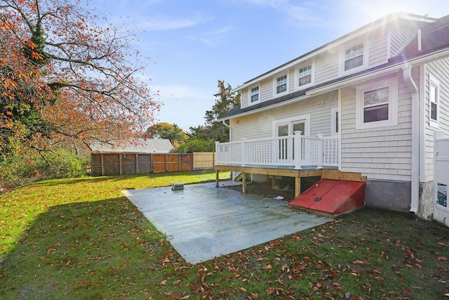 rear view of property featuring a wooden deck and a lawn