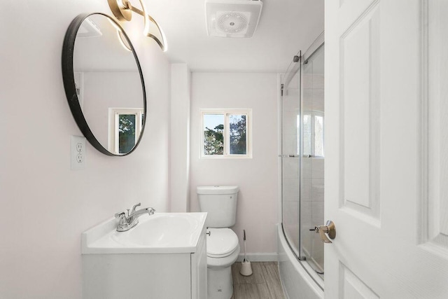 full bathroom with combined bath / shower with glass door, toilet, and vanity