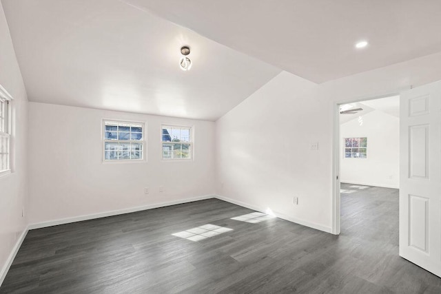 spare room with vaulted ceiling and dark wood-type flooring