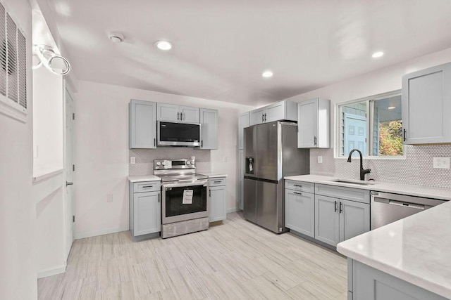 kitchen with sink, appliances with stainless steel finishes, and gray cabinetry