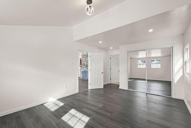 unfurnished living room with dark hardwood / wood-style flooring and vaulted ceiling