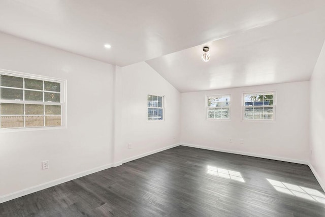 empty room featuring dark wood-type flooring and lofted ceiling