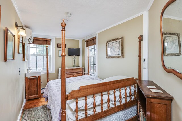 bedroom featuring crown molding, hardwood / wood-style floors, and baseboard heating