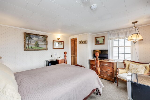 carpeted bedroom with ornamental molding