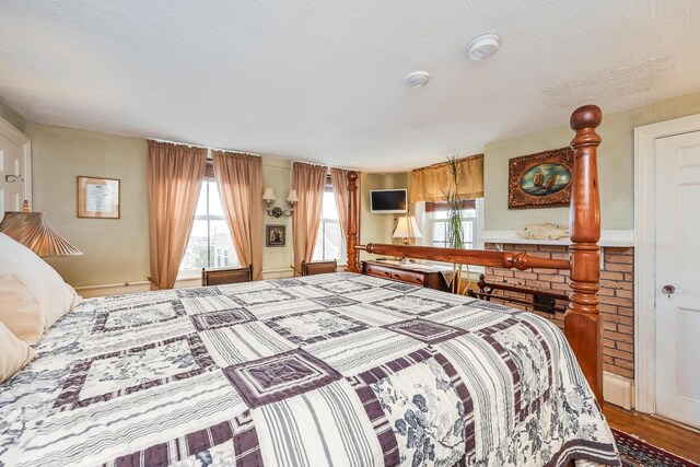 bedroom with hardwood / wood-style floors and a textured ceiling