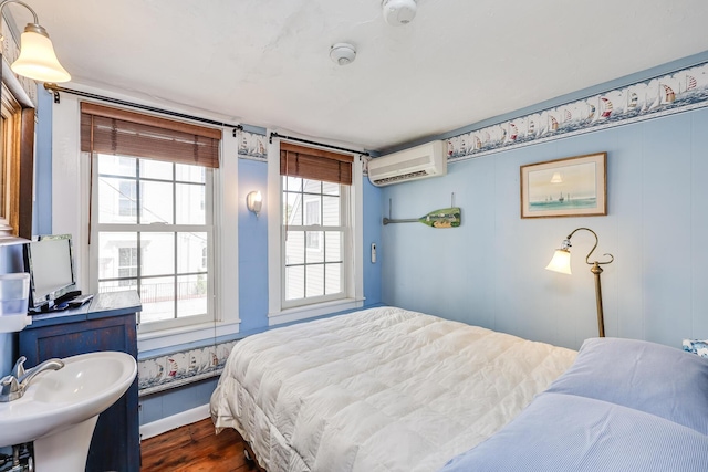 bedroom with dark wood-type flooring and a wall unit AC