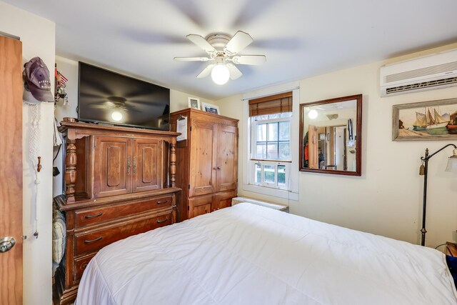 bedroom with ceiling fan and a wall mounted air conditioner