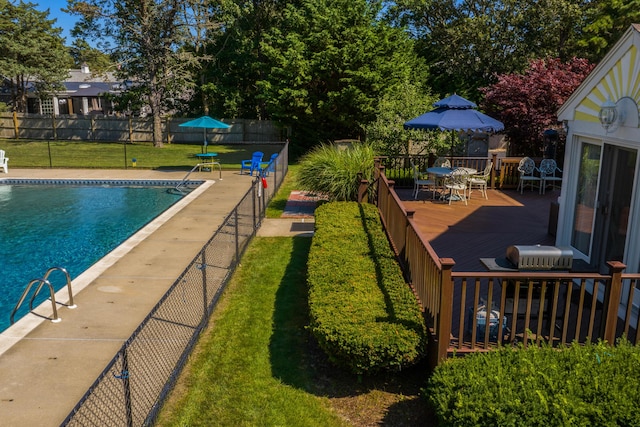 view of swimming pool featuring a yard and a deck