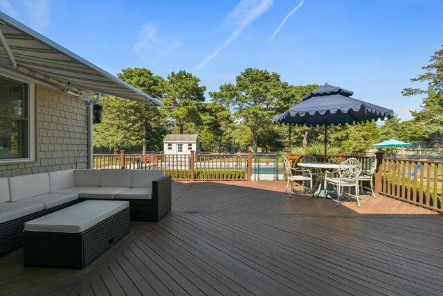 wooden terrace with an outdoor living space and an outbuilding