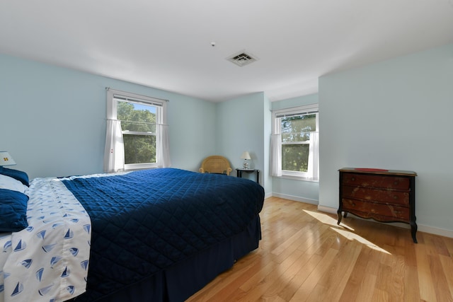 bedroom featuring light hardwood / wood-style floors and multiple windows