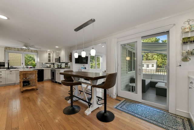 dining space featuring crown molding, light hardwood / wood-style floors, and ceiling fan