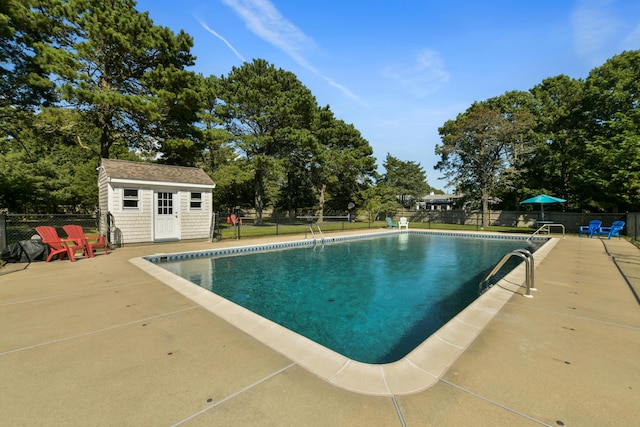 view of swimming pool with an outbuilding and a patio