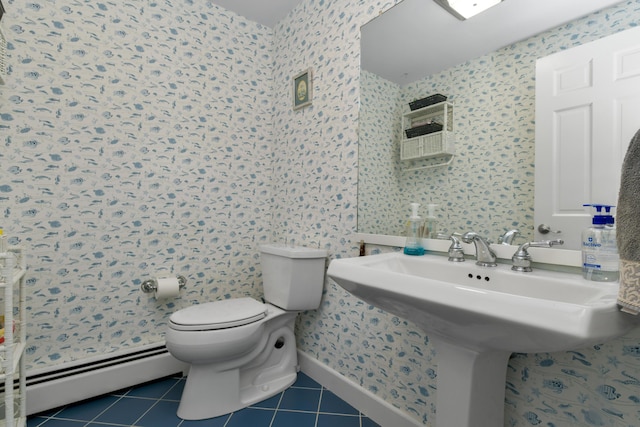 bathroom with toilet, a baseboard heating unit, and tile patterned flooring