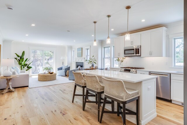 213 N Falmouth Hwy Unit 5A, North Falmouth, MA 02556 - kitchen with white cabinets, ornamental molding, appliances with stainless steel finishes, and open floor plan
