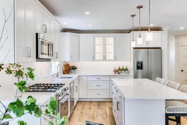 213 N Falmouth Hwy Unit 5A, North Falmouth, MA 02556 - kitchen featuring a sink, stainless steel appliances, a breakfast bar, light countertops, and a center island