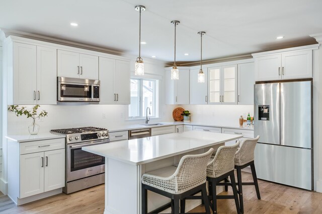 213 N Falmouth Hwy Unit 5A, North Falmouth, MA 02556 - kitchen with a breakfast bar, light countertops, appliances with stainless steel finishes, a kitchen island, and tasteful backsplash