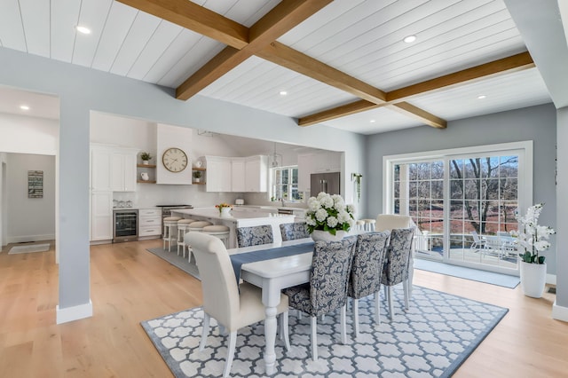 dining room featuring a wealth of natural light, wine cooler, light wood-style floors, and beamed ceiling