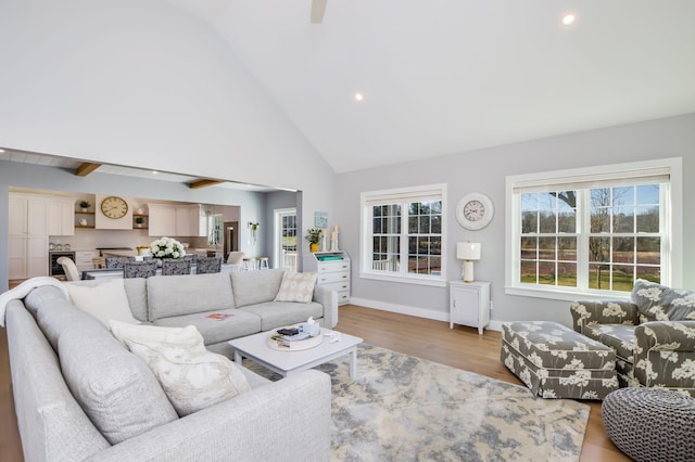living area with high vaulted ceiling, baseboards, light wood-style floors, and recessed lighting