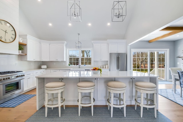 kitchen featuring a wealth of natural light, high quality appliances, a kitchen island, and white cabinets
