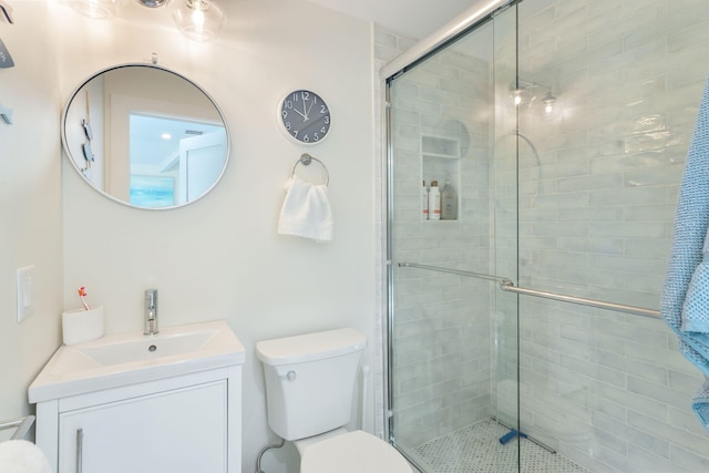 bathroom with toilet, vanity, and a stall shower