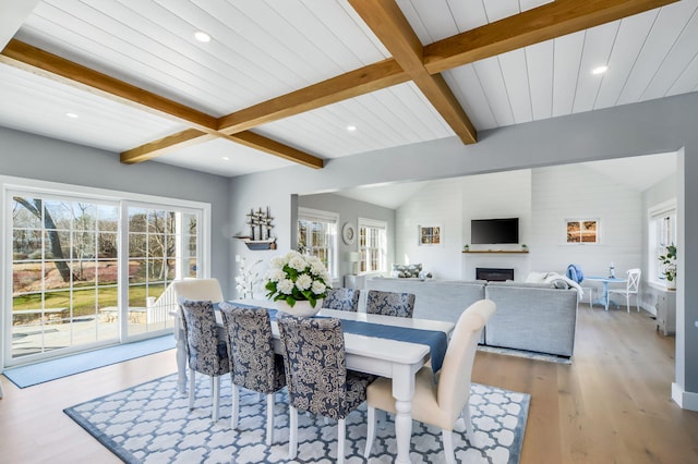 dining area with recessed lighting, lofted ceiling with beams, a fireplace, and wood finished floors