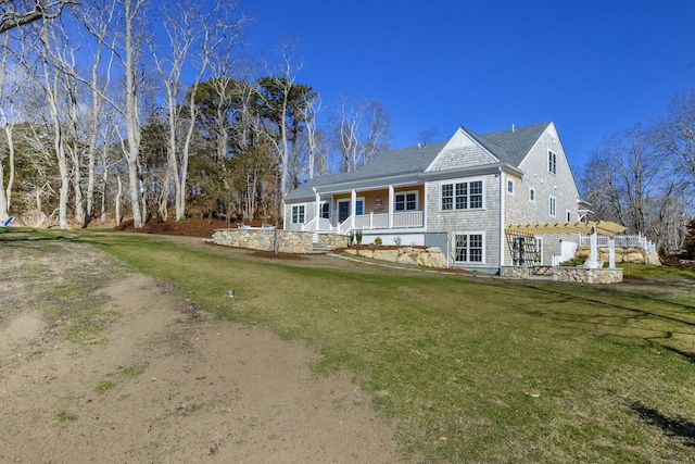 rear view of house featuring a pergola, a lawn, and a porch