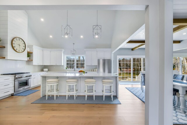 kitchen with light countertops, stainless steel appliances, white cabinets, and light wood finished floors