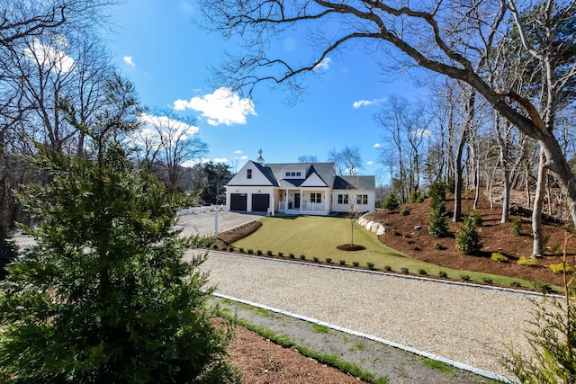 shingle-style home with a front yard, driveway, and a garage