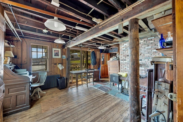 below grade area with radiator heating unit and wood-type flooring