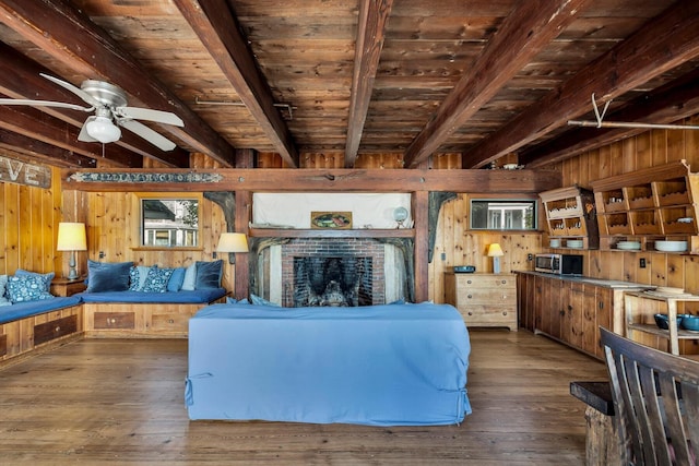 living area with wood ceiling, wooden walls, and beamed ceiling