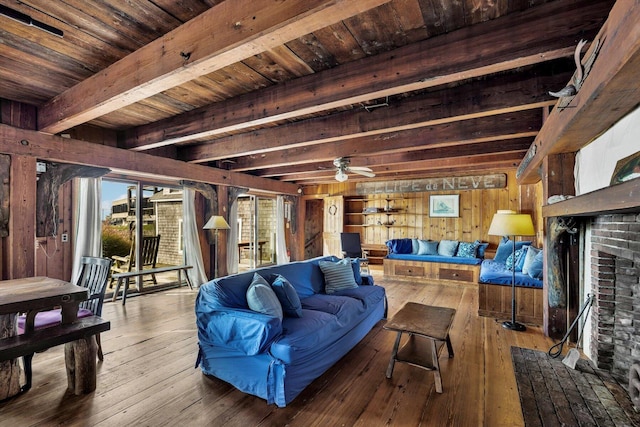 living area with ceiling fan, wooden ceiling, wooden walls, wood-type flooring, and beam ceiling