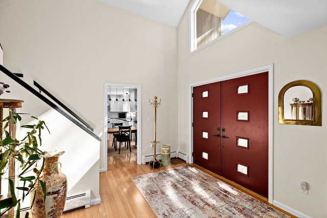 39 Fox Run Ln, East Falmouth, MA 02536 - entryway featuring a baseboard radiator, light wood-style flooring, a towering ceiling, and baseboards