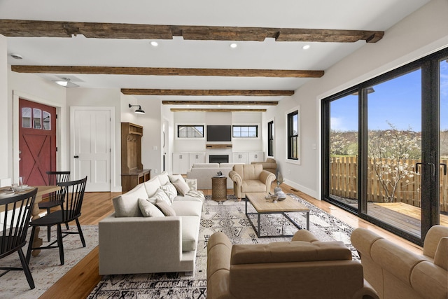living room with wood finished floors, a fireplace, beam ceiling, baseboards, and recessed lighting