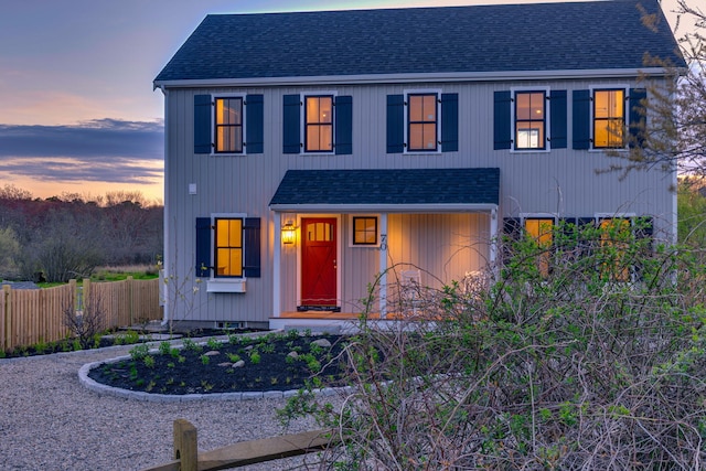 modern farmhouse style home with a shingled roof and fence