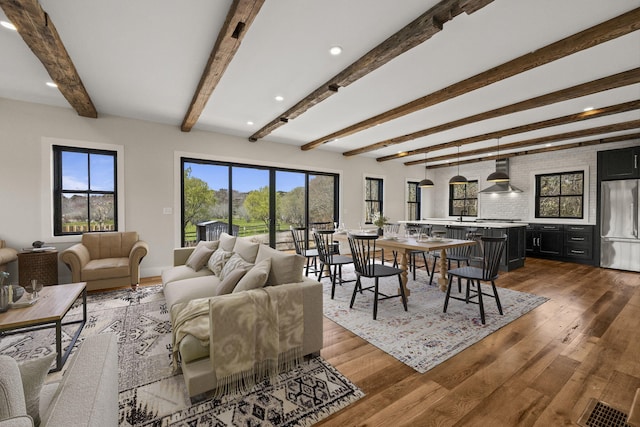 living room featuring beam ceiling and wood finished floors